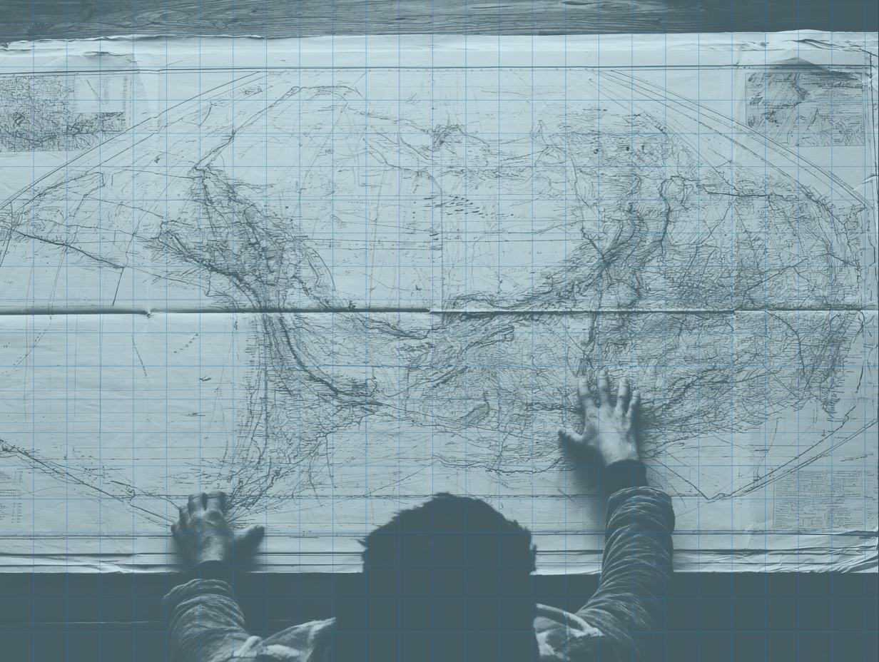 Hands assembling torn map pieces into a whole